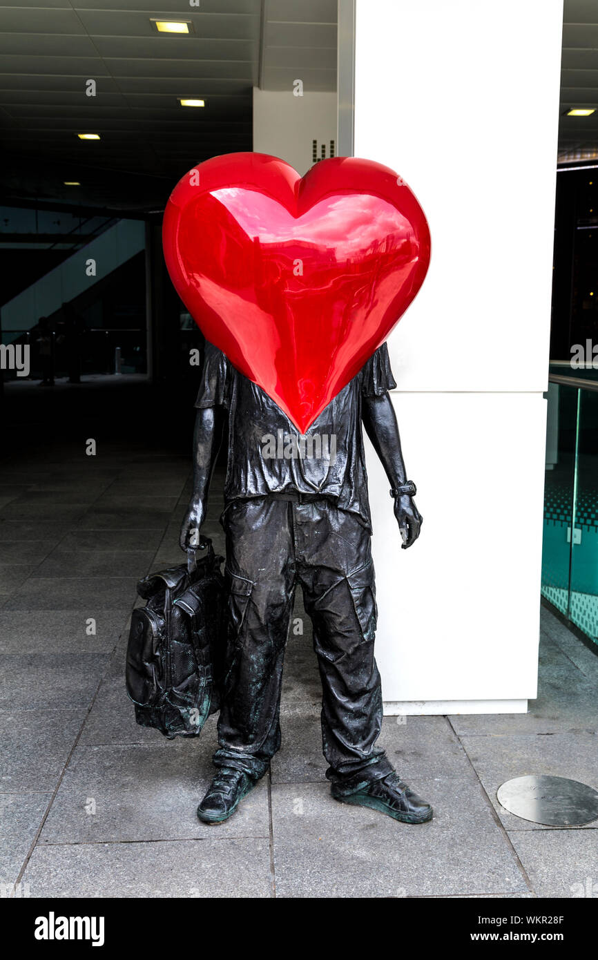 Sculpture of a men with a heart as the head, holding a backpack, 'The Lovely People' by Temper, Birmingham, UK Stock Photo
