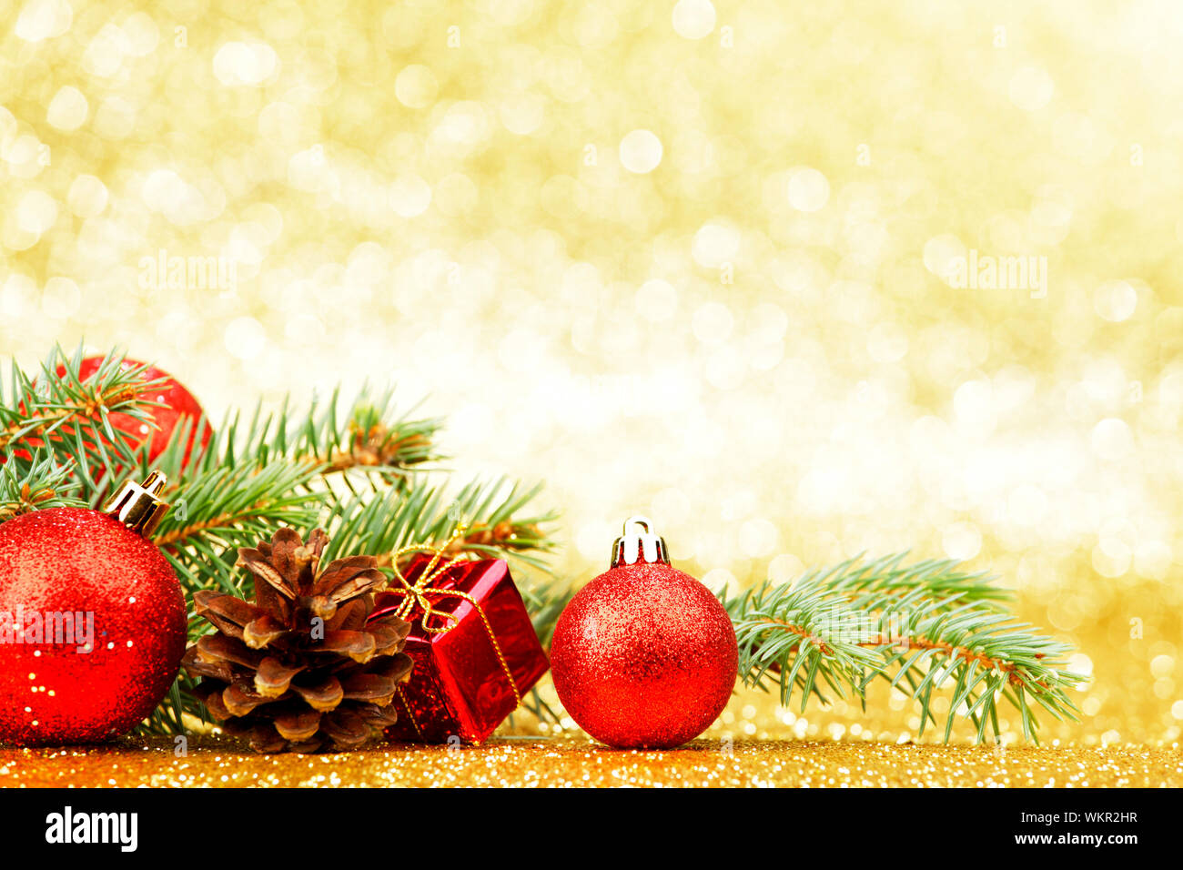 Christmas card with fir tree branch and decoration on golden glitter ...