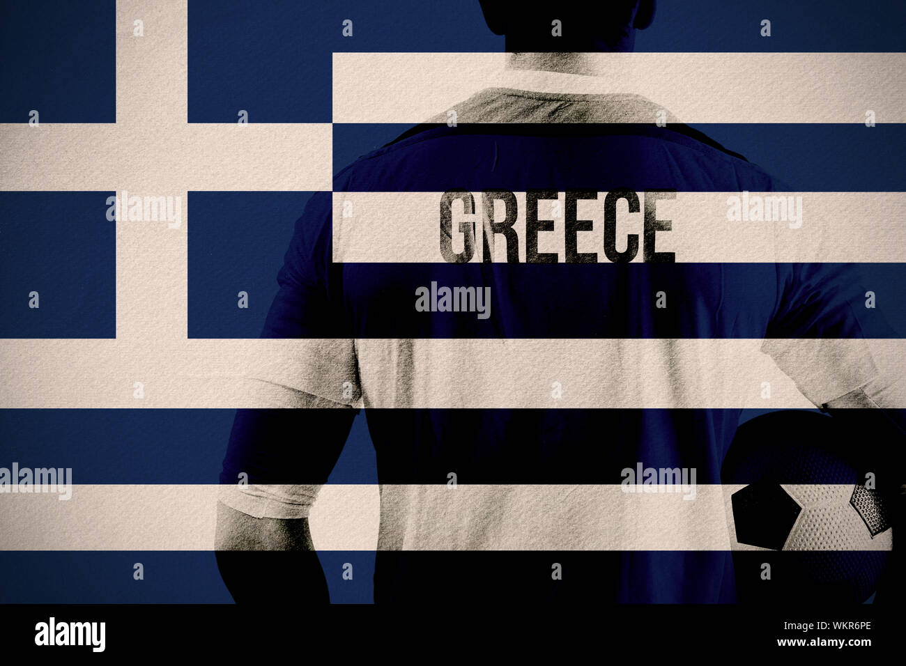 Greece football player holding ball against greece national flag Stock Photo