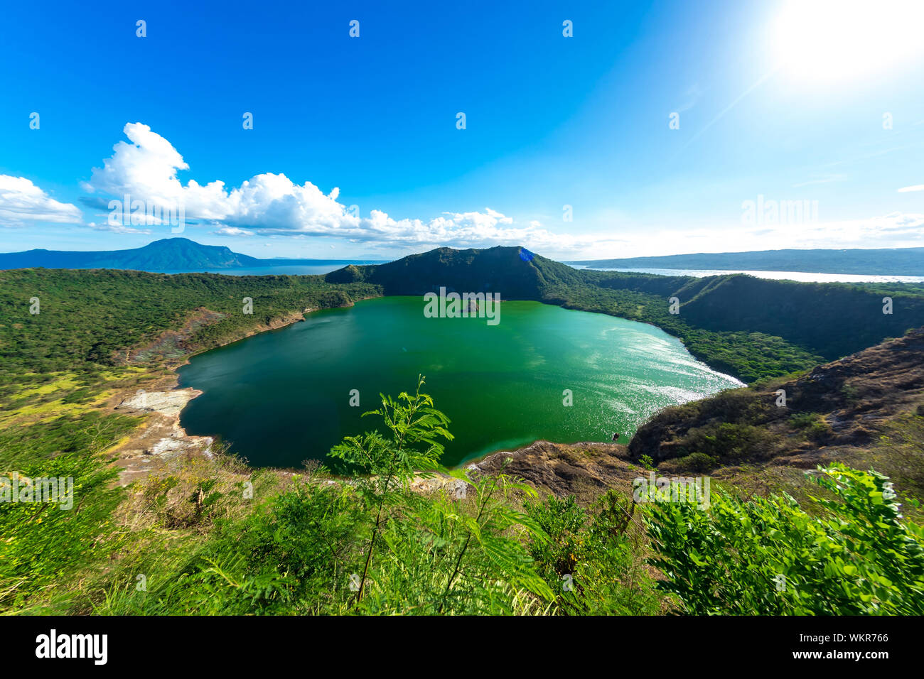 View of cones of Taal Volcano and the wind ruffled emerald green water in the Lake Taal on a sunny day in Tagaytay, Philippines. Stock Photo