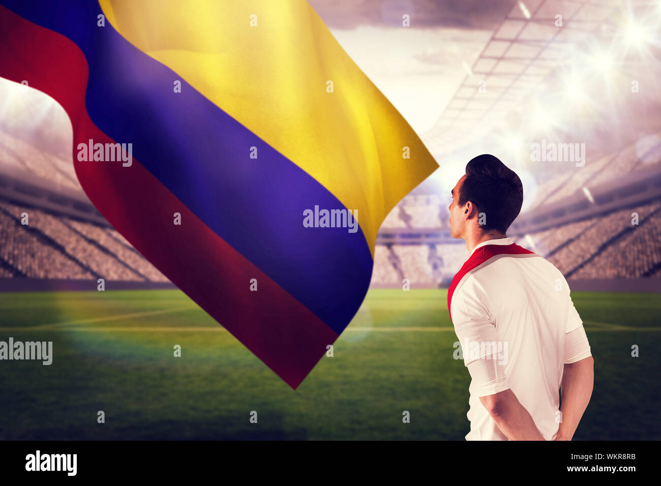 Handsome football fan looking ahead against large football stadium with lights Stock Photo