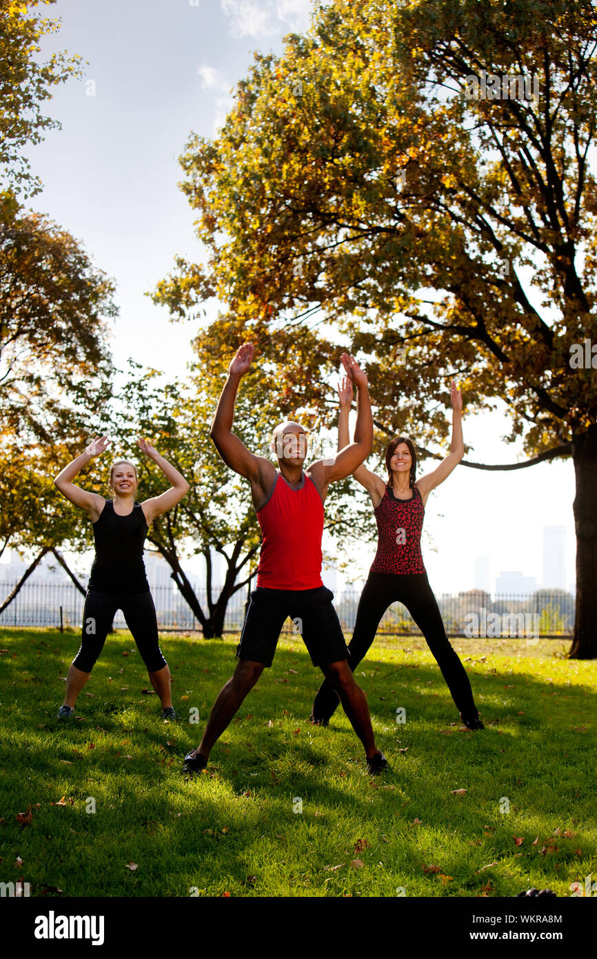 A group of people doing jumping jacks in the park Stock Photo