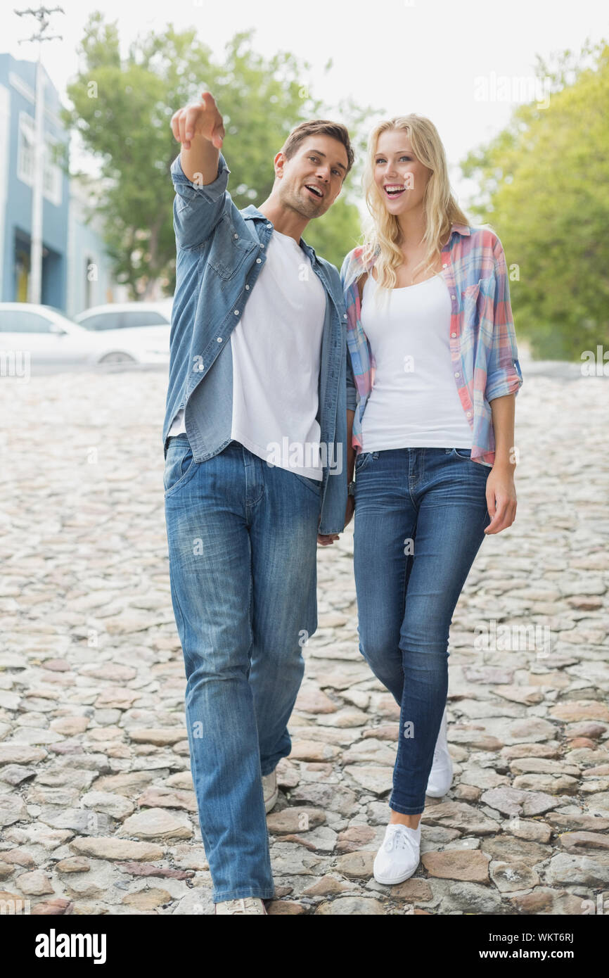 Hip young couple walking holding hands on a sunny day in the city Stock ...