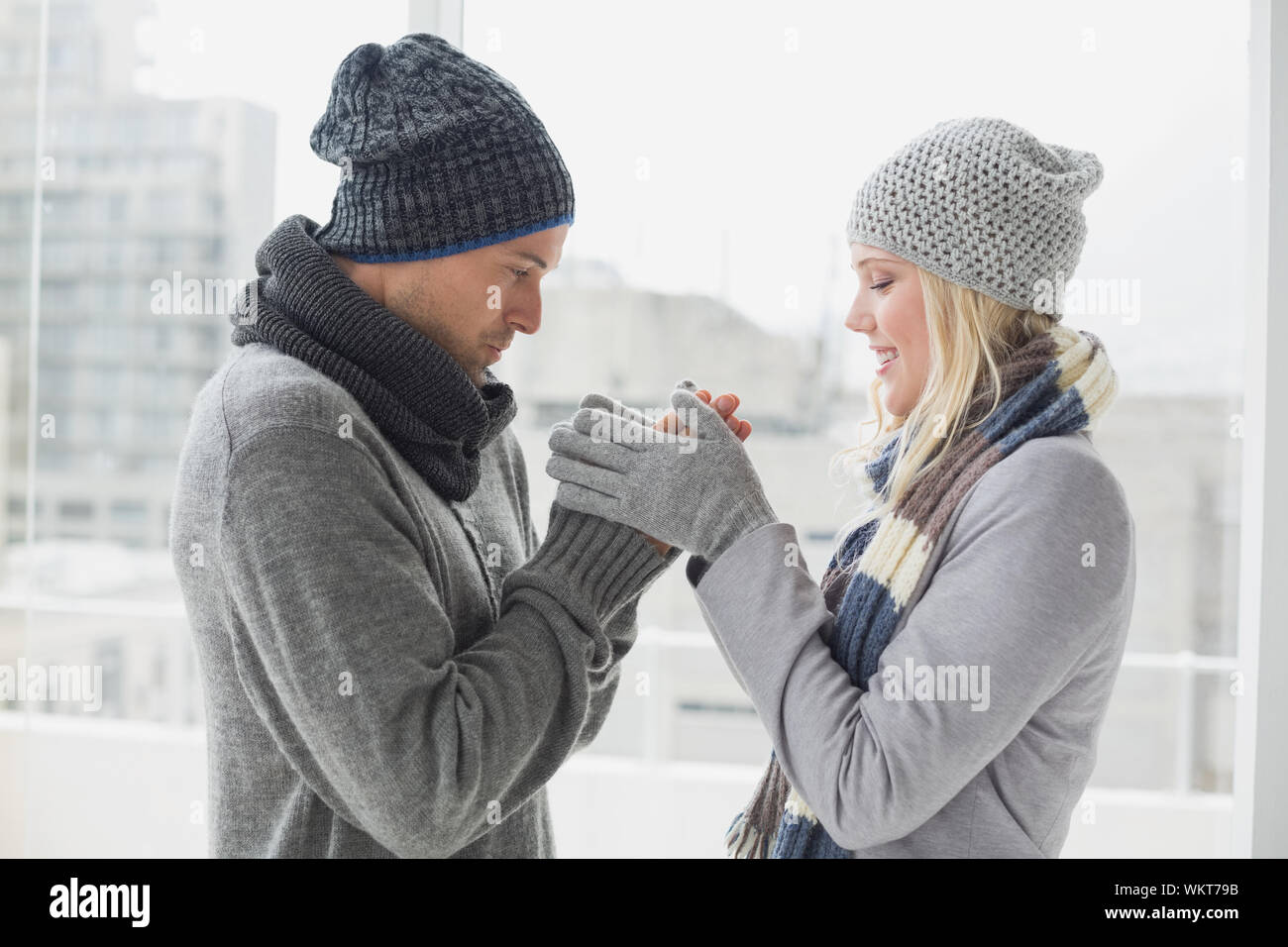 Cute couple in warm clothing smiling at each other on a chilly day ...
