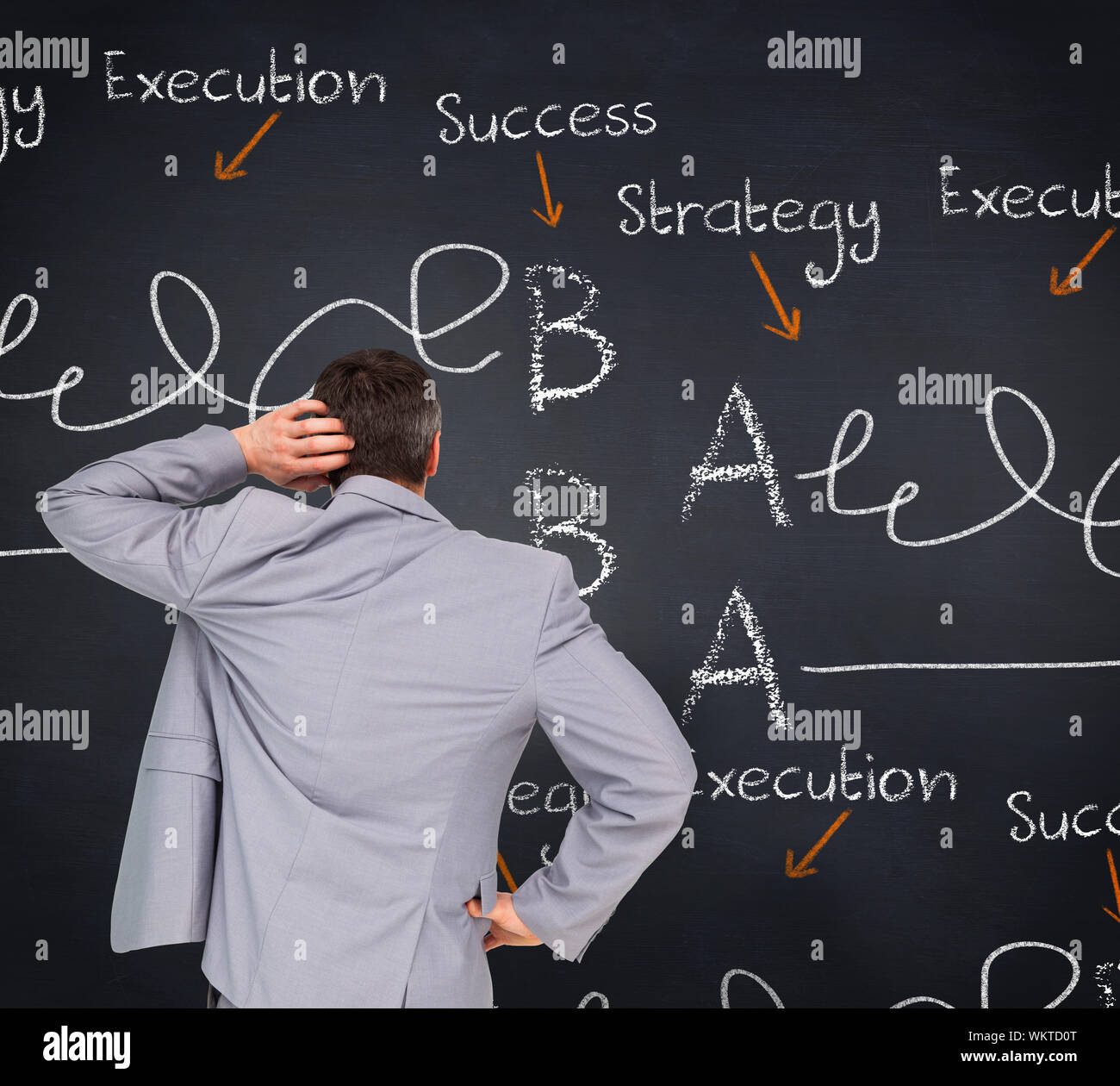 Thinking businessman against blackboard with business buzzwords Stock Photo