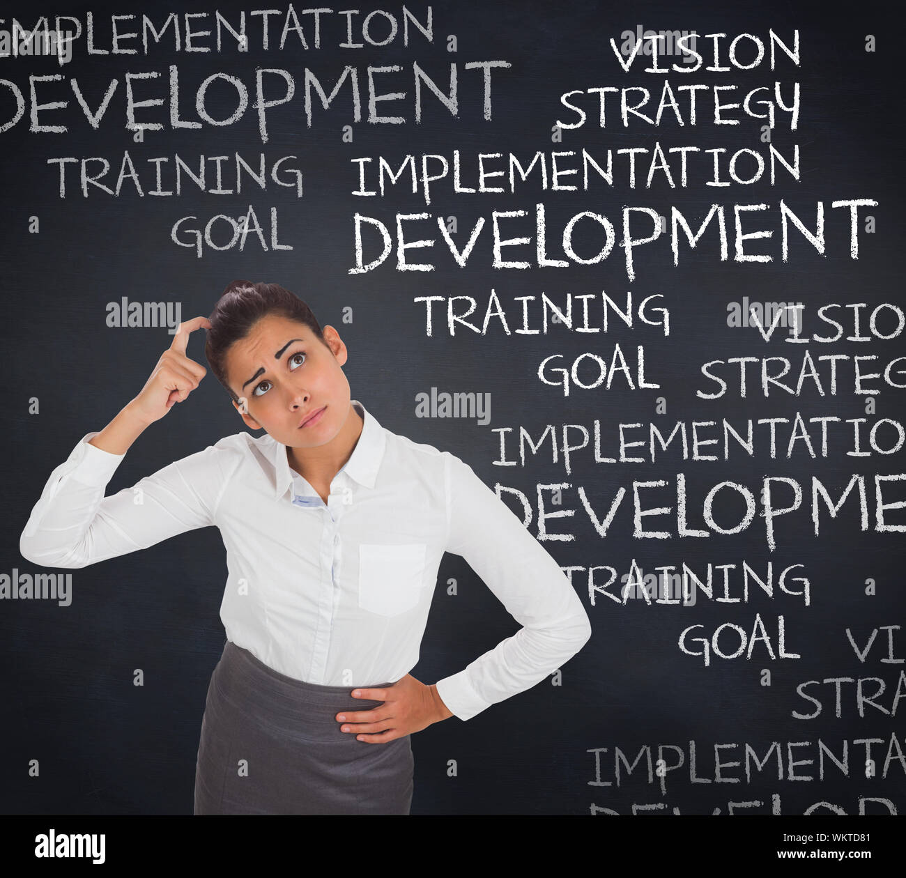 Worried businesswoman against blackboard with business buzzwords Stock Photo