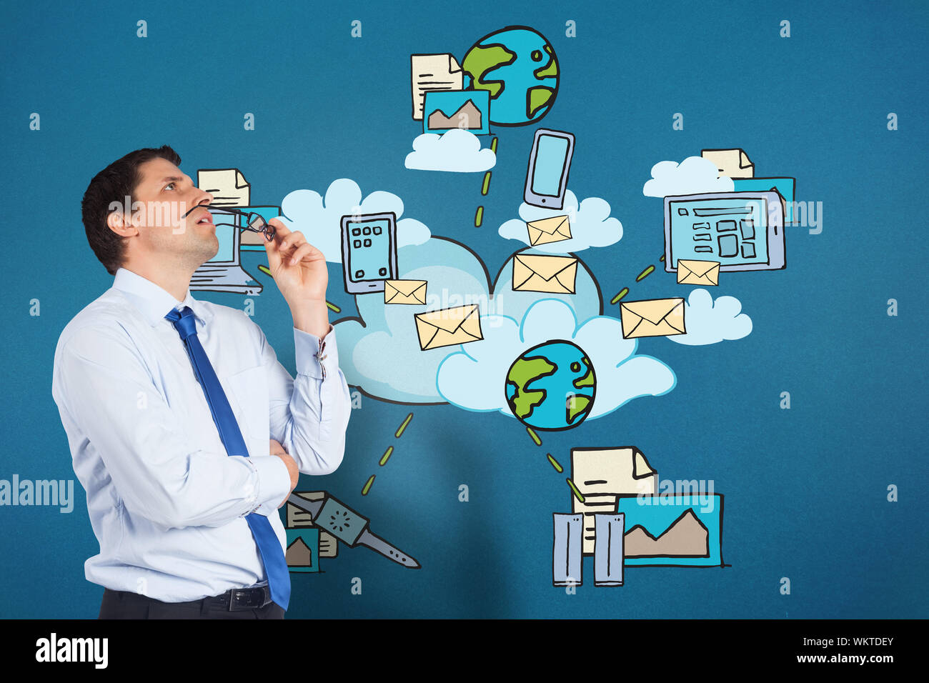 Thinking businessman biting glasses against cloud computing doodle Stock Photo