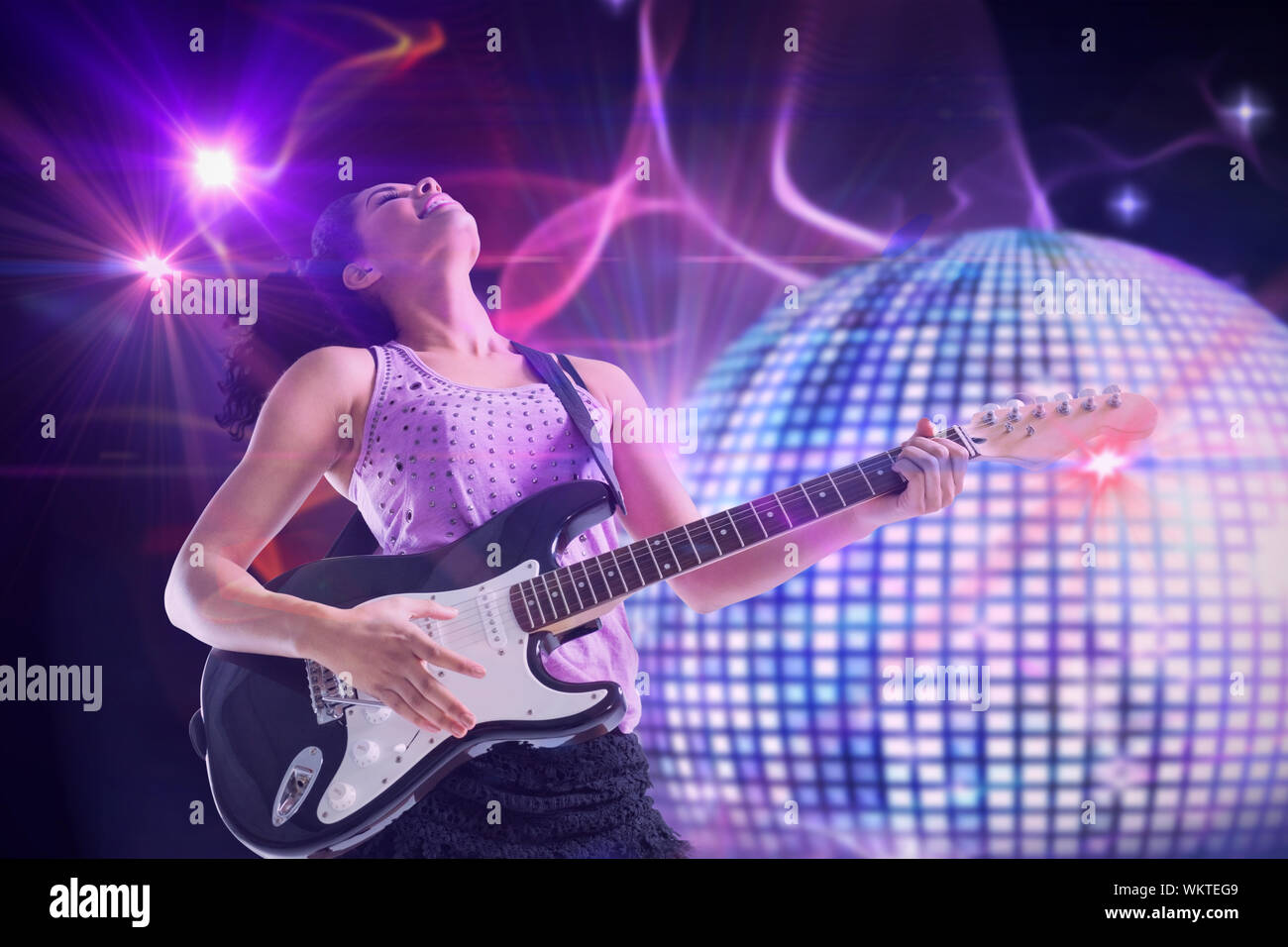 Pretty girl playing guitar against digitally generated shiny disco ball  Stock Photo - Alamy