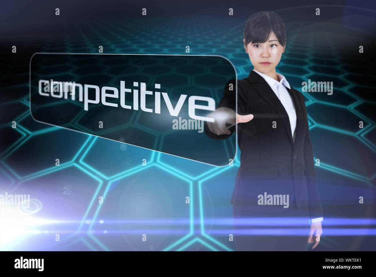 Businesswoman pointing to word competitive against black background with shiny hexagons Stock Photo