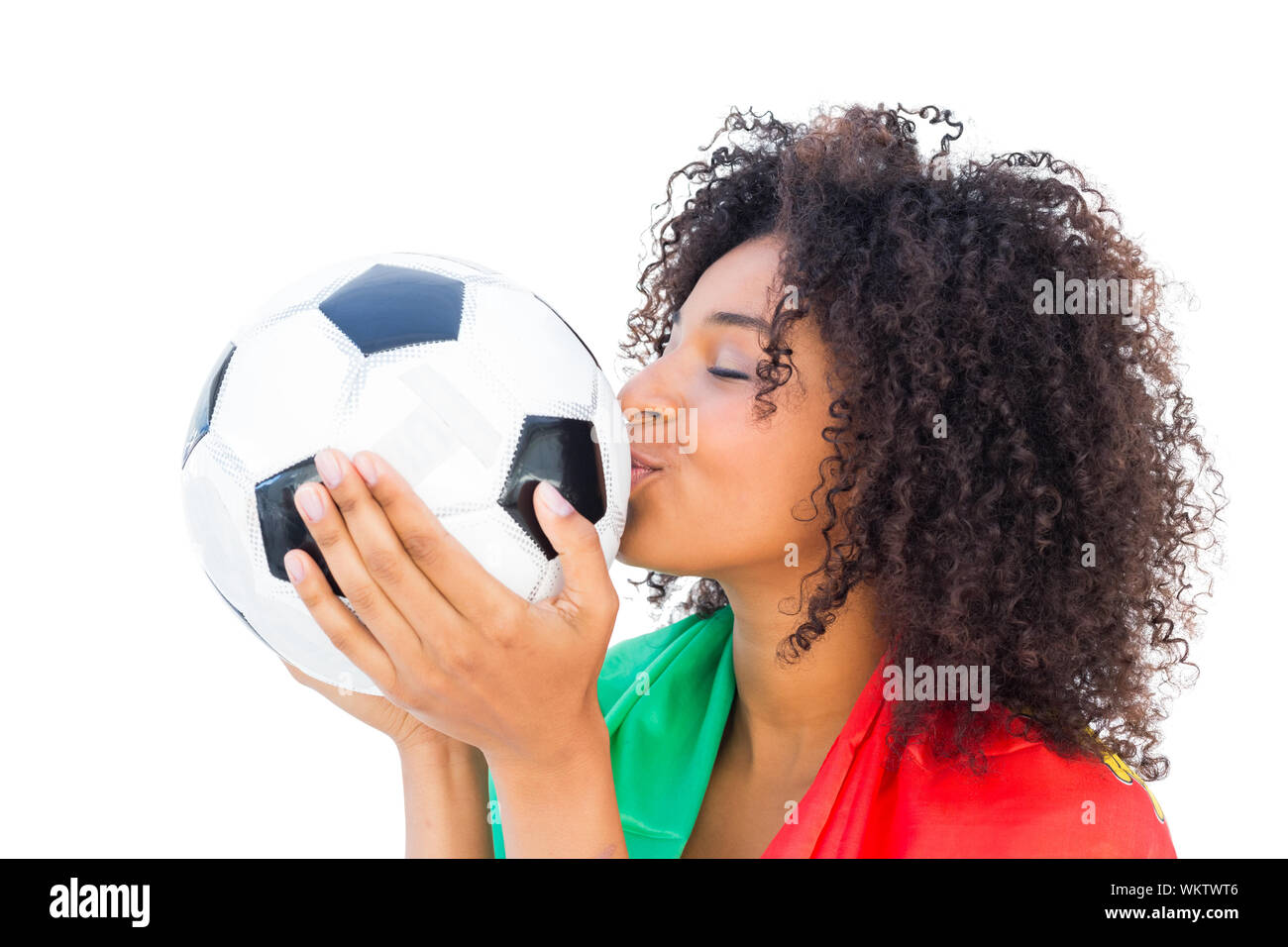 Pretty football fan with portugal flag kissing ball on white background Stock Photo