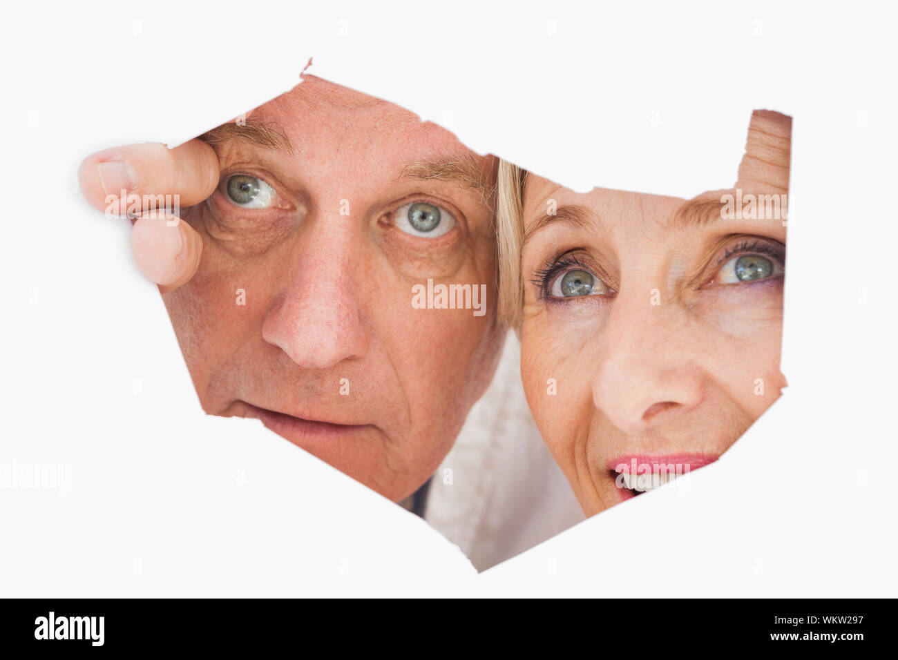 Elderly Rip Older couple looking through rip on white background Stock Photo - Alamy