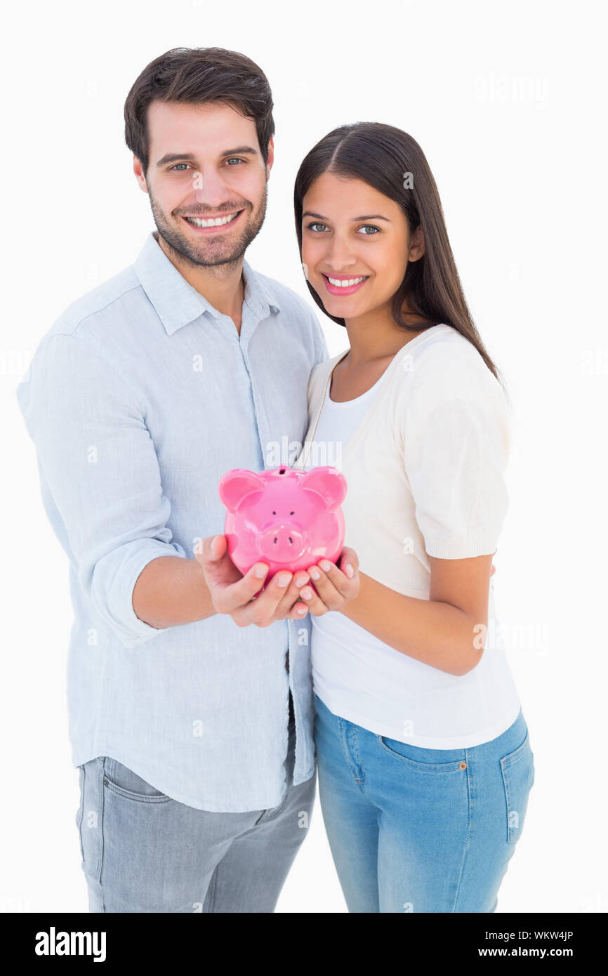 Happy couple showing their piggy bank on white background Stock Photo ...