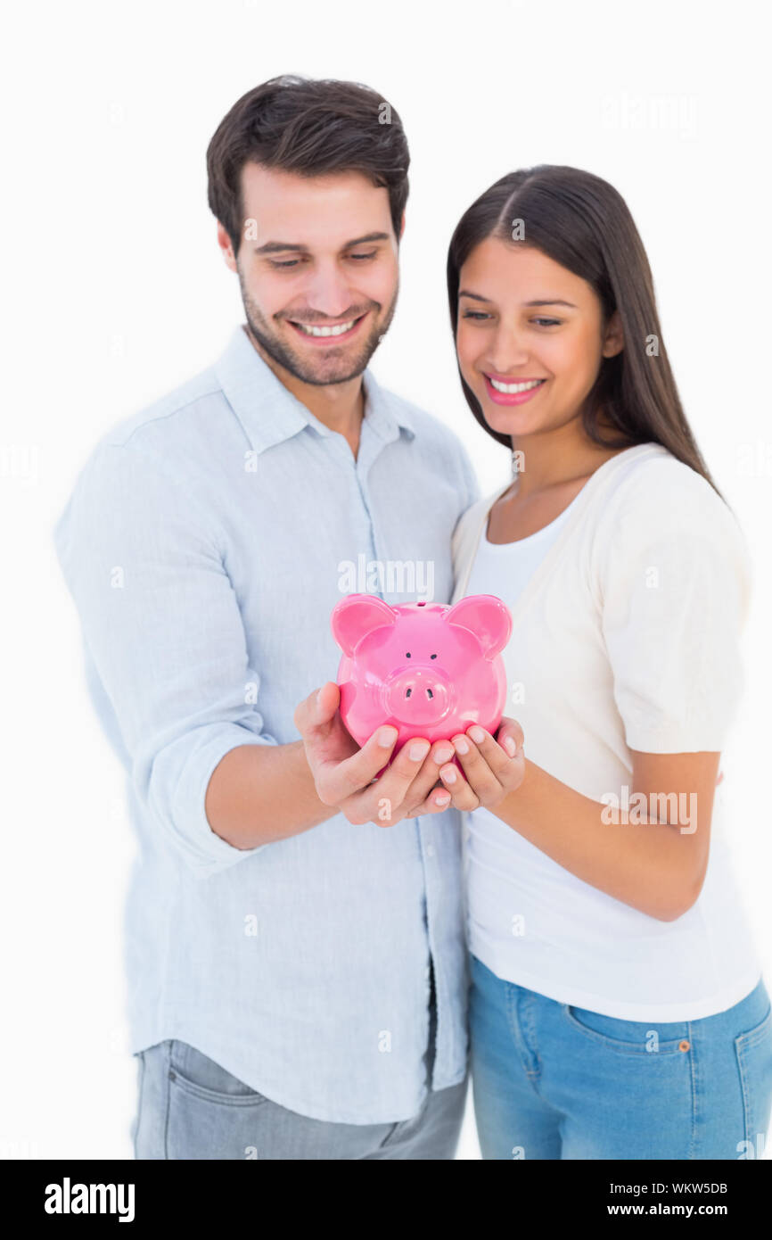 Happy couple holding their piggy bank on white background Stock Photo ...