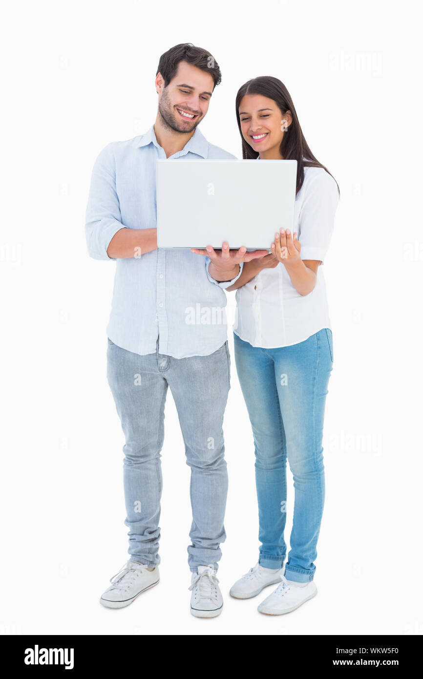 Attractive young couple holding their laptop on white background Stock ...