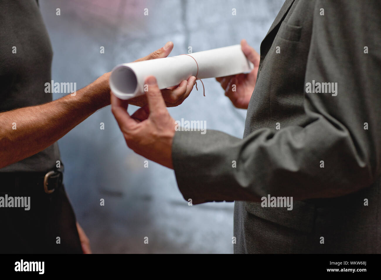 Architect handing blueprints to businessman. Stock Photo