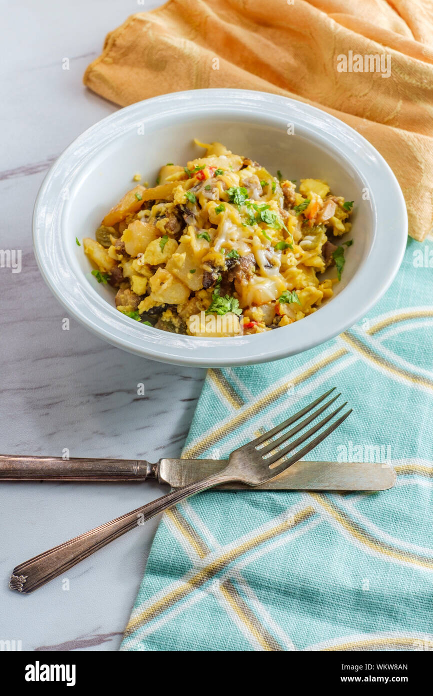 Breakfast egg scramble bowl with sausage potatoes mushrooms and cheddar