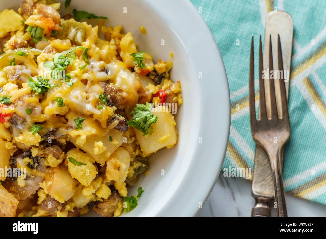 Breakfast egg scramble bowl with sausage potatoes mushrooms and cheddar