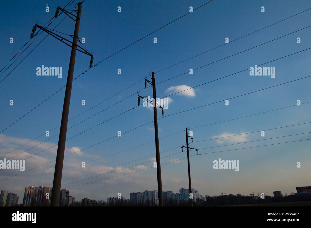 high voltage power line against a blue sky with clouds Stock Photo - Alamy