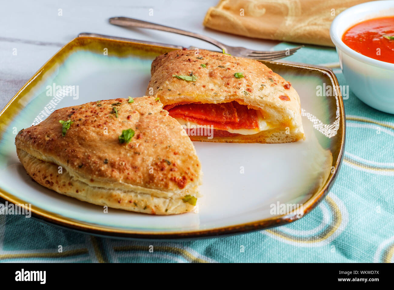 Italian pastry pepperoni and cheese calzone with tomato marinara