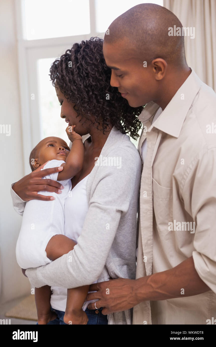 Happy parents spending time with baby at home in the living room Stock