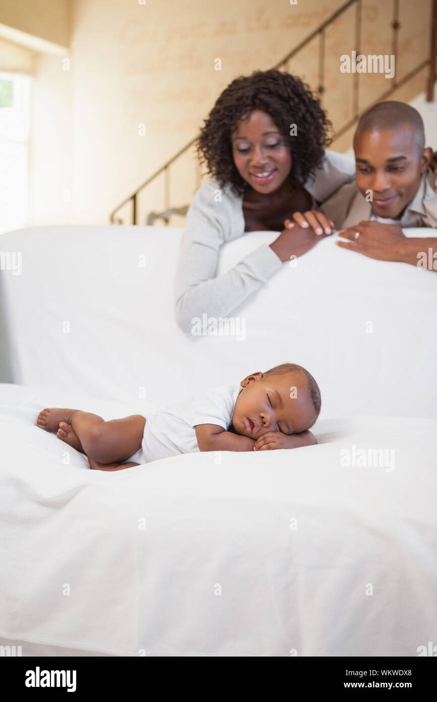 Baby Boy Sleeping Peacefully On Couch Watched By Parents At