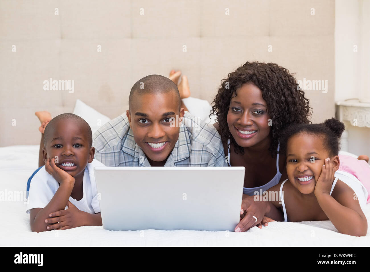 Happy family using laptop together on bed at home in the bedroom Stock ...