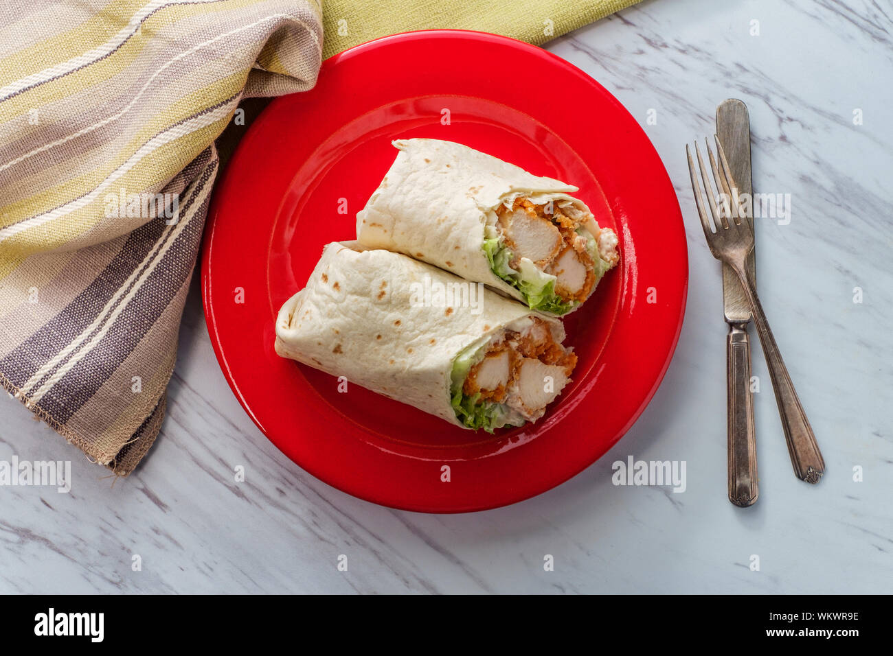 Crispy chicken Caesar salad wrap sandwich with romaine lettuce Stock