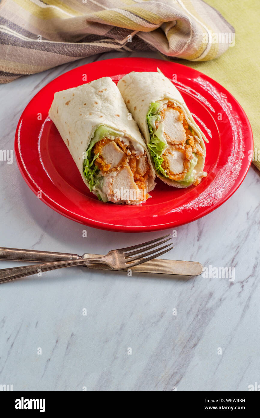 Crispy chicken Caesar salad wrap sandwich with romaine lettuce Stock
