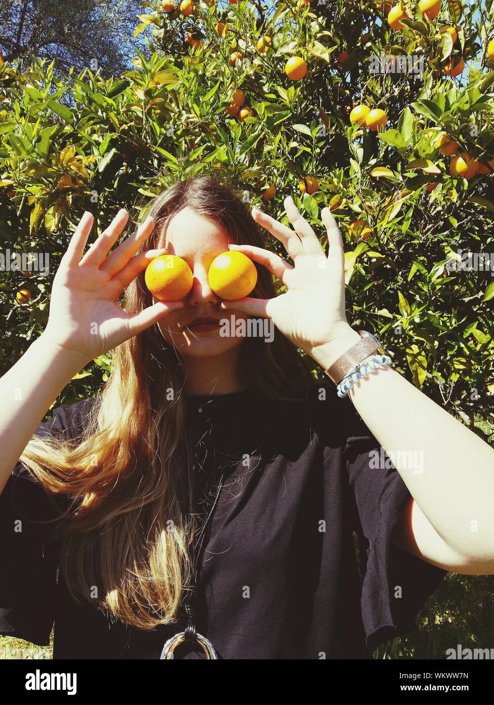 Young Woman Holding Oranges On Her Face Against Tree At Farm Stock Photo Alamy Orange toner for face/diy orange toner/orange peel toner/orange skin 3 yıl önce. alamy