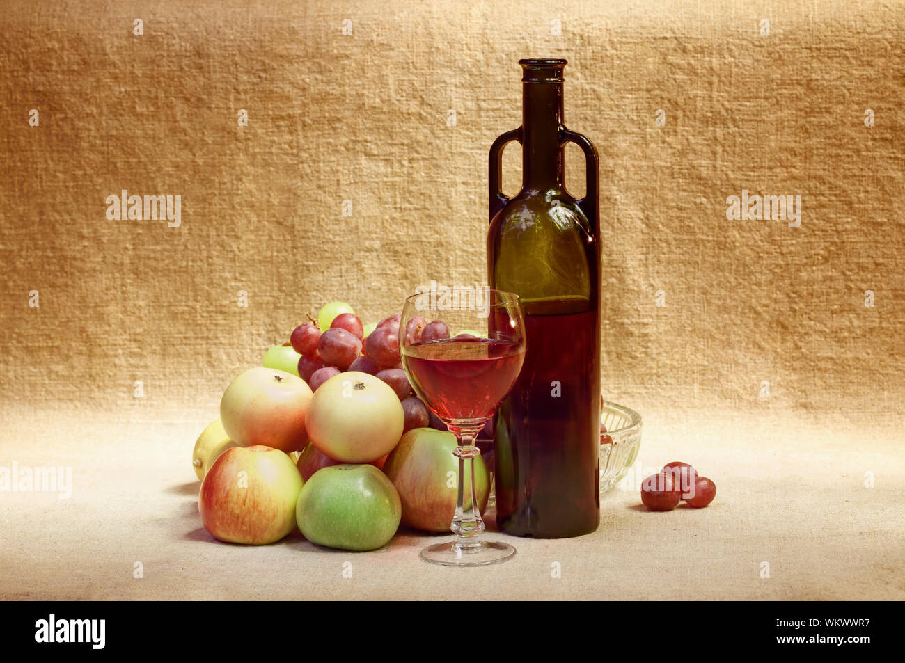 Still-life from a bottle of wine and fruit against a canvas Stock Photo ...