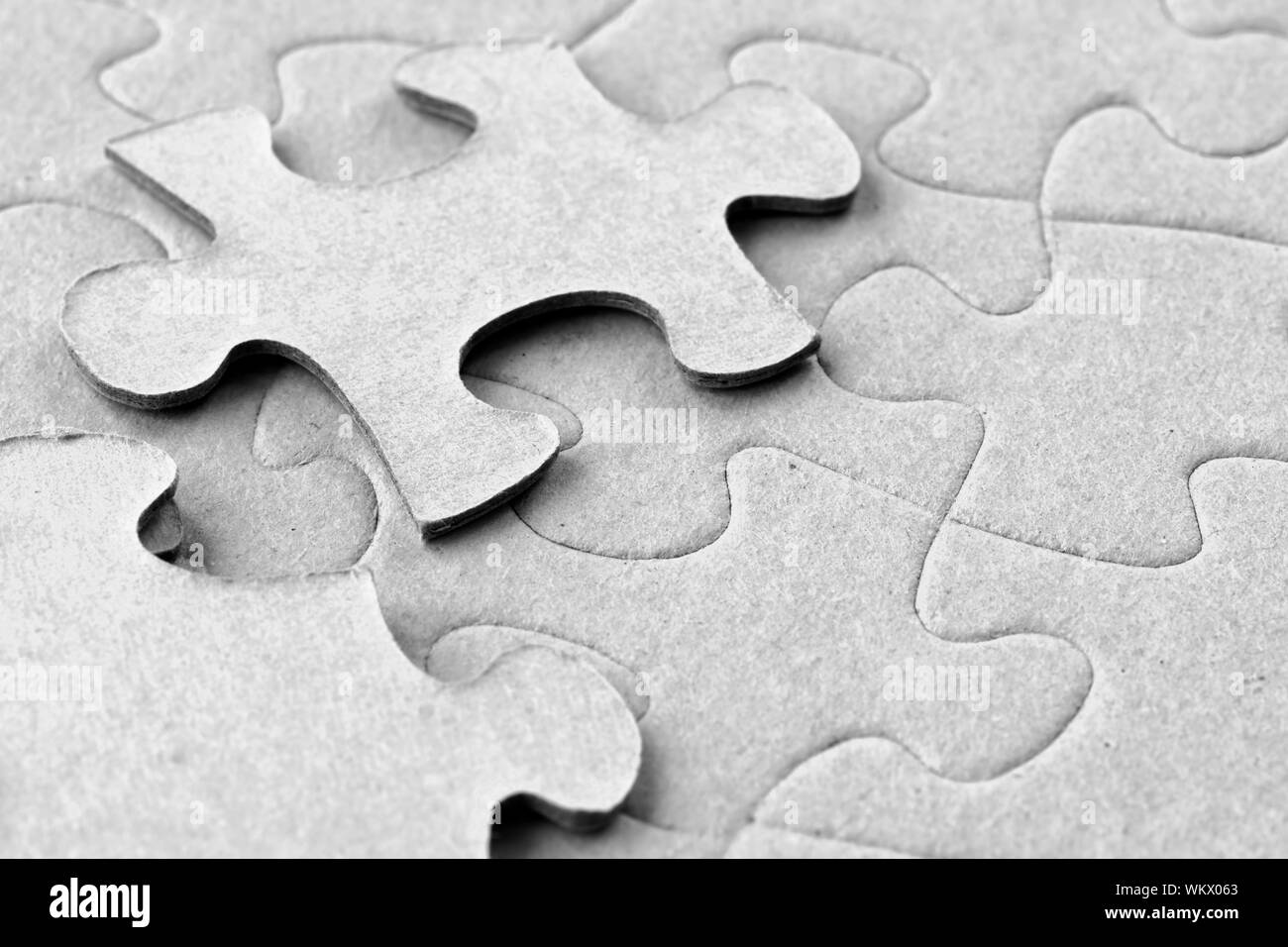 Photograph of blank grey cardboard jigsaw puzzle with two floating pieces on top, great material