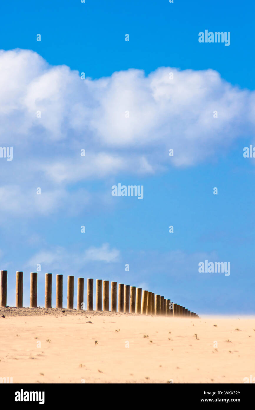 Wooden fence dissapearing into the infinity of the dessert. Stock Photo