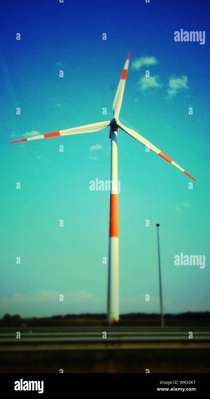 View Of Wind Turbine On Landscape Against Blue Sky Stock Photo
