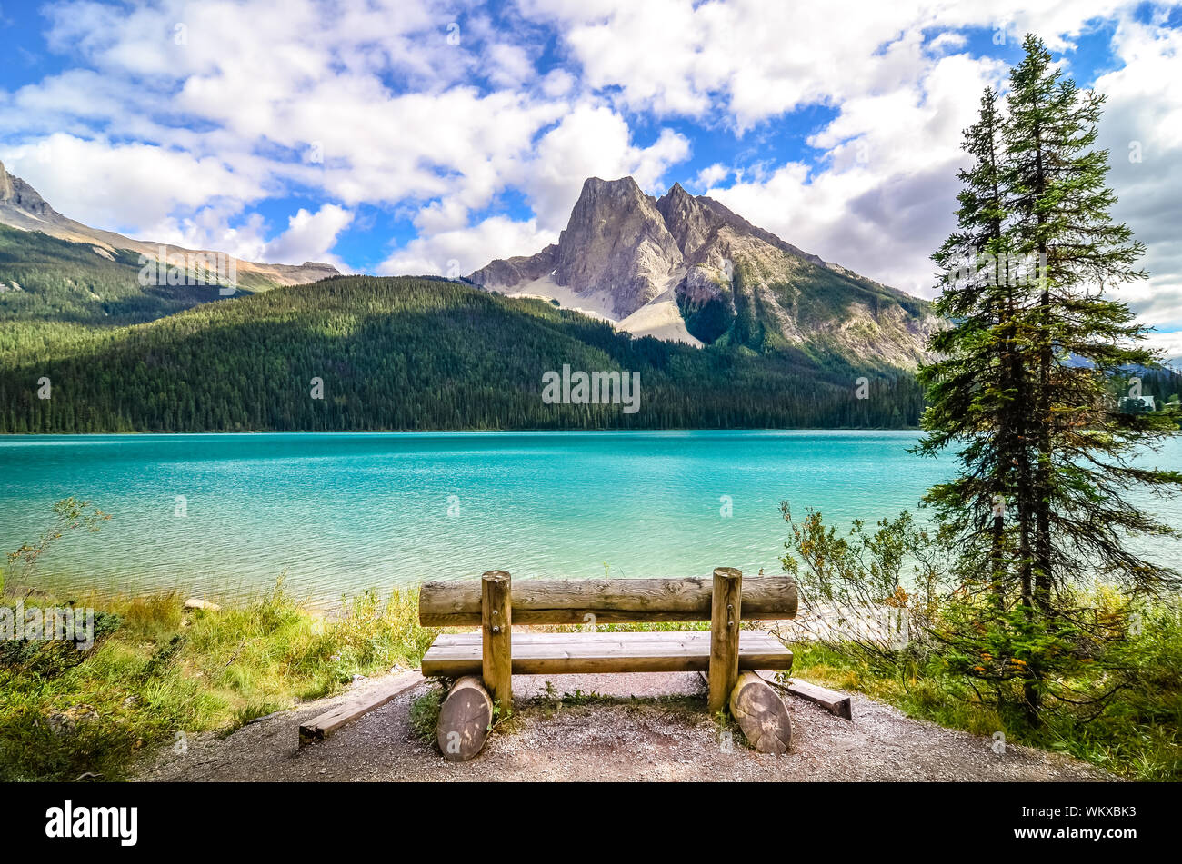 Scenic view of mountain lake and wooden bench, Emerald Lake, Banff ...