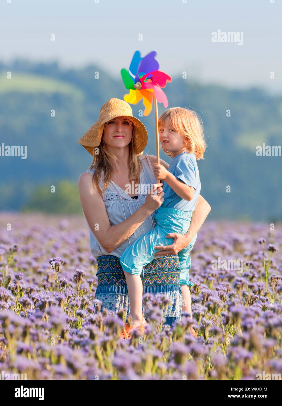 portrait of mother and son playing with pinwheel in a field Stock Photo ...