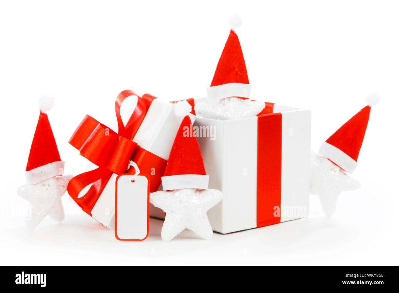 White gift box with red ribbon, stars with santa claus hats isolated on ...