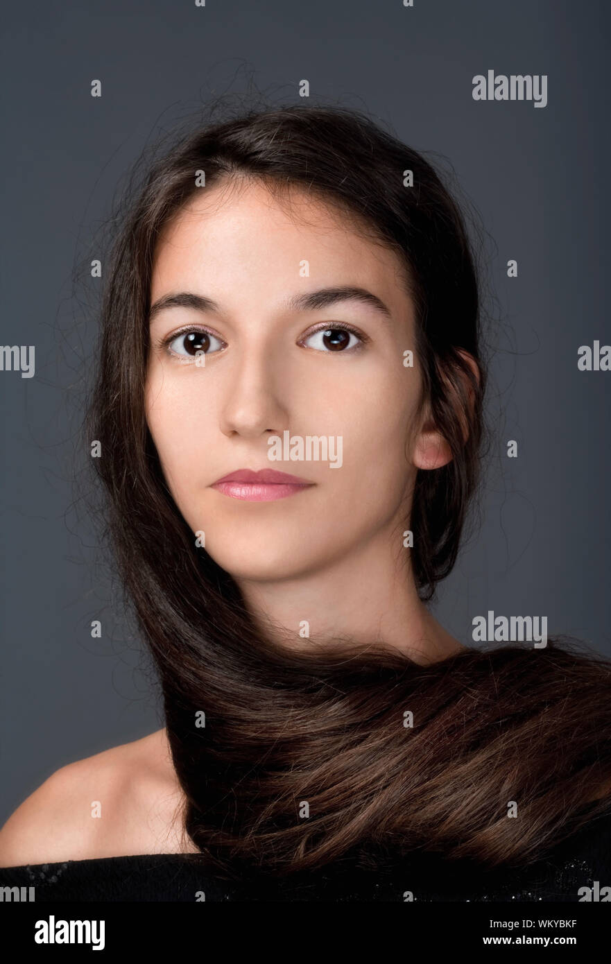 portrait of a woman with brown hair and brown eyes - isolated on gray ...