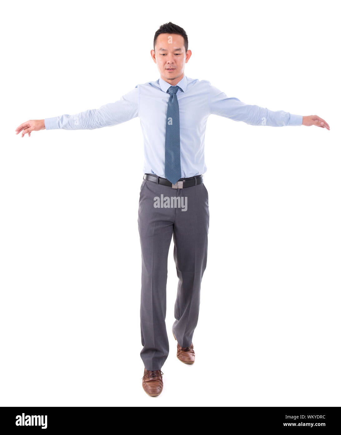 Asian business man walking balance, front view full length isolated over white background. Stock Photo