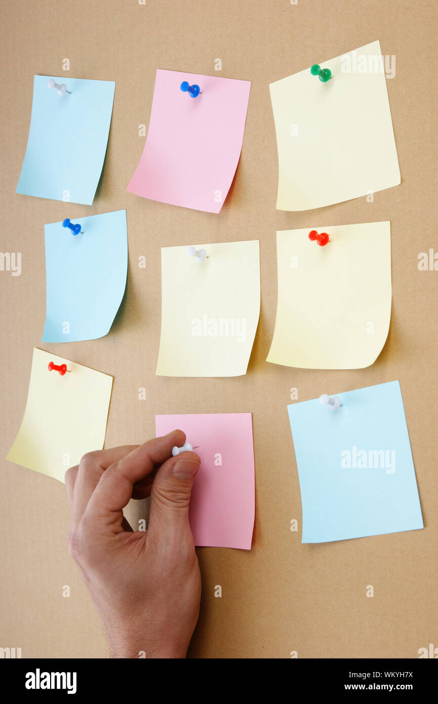 leaflets with advertisements pinned on the bulletin board Stock Photo