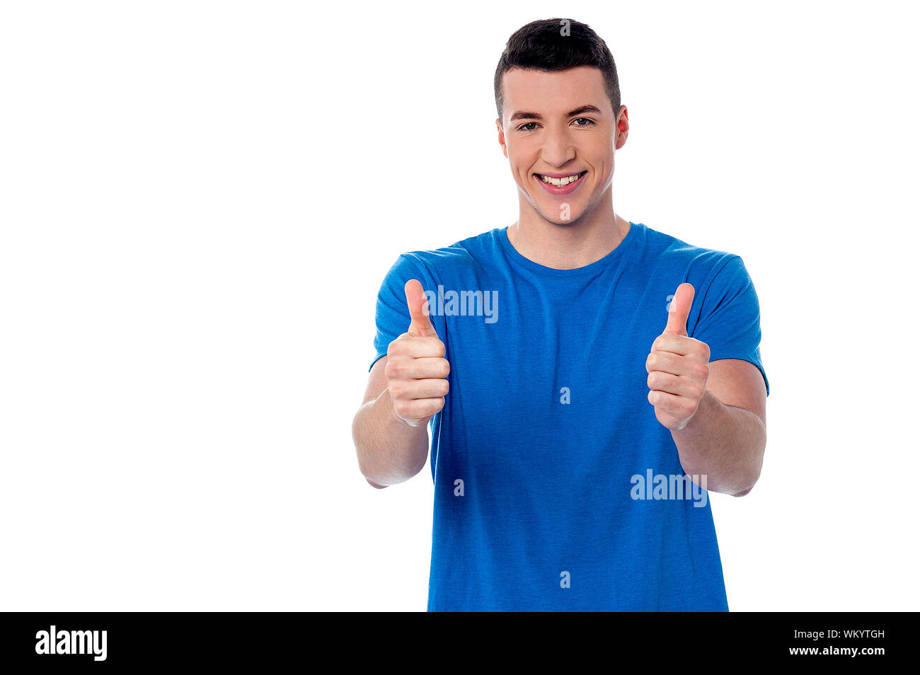 Handsome young guy showing double thumbs down Stock Photo - Alamy