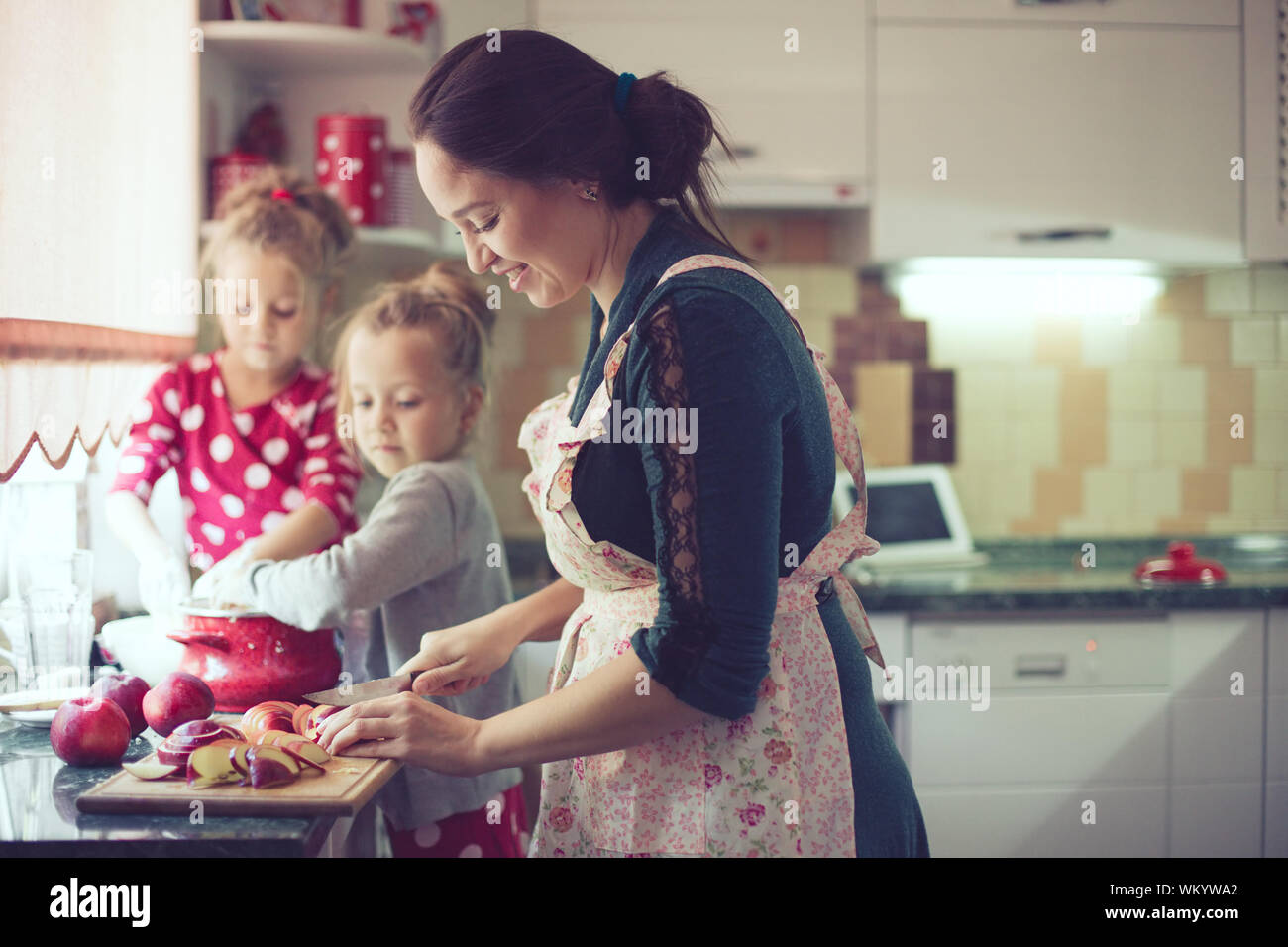 Mother With Her 5 Years Old Kids Cooking Holiday Pie In The