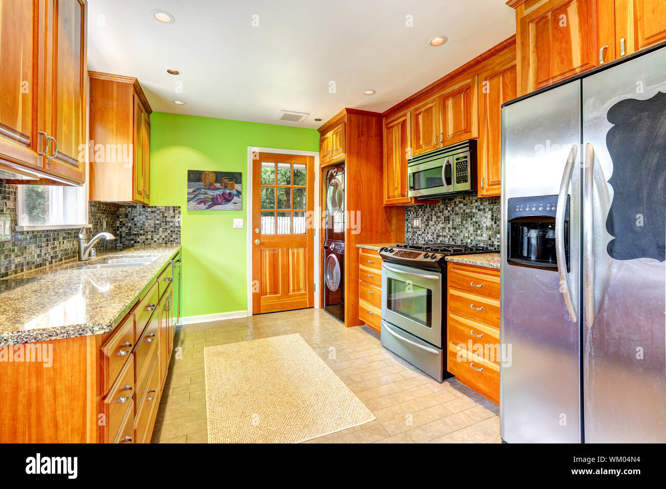Maple Kitchen Cabinets With Mosaic Back Splash Trim And Granite Tops Bright Kitchen Room With Green Wall Stock Photo Alamy