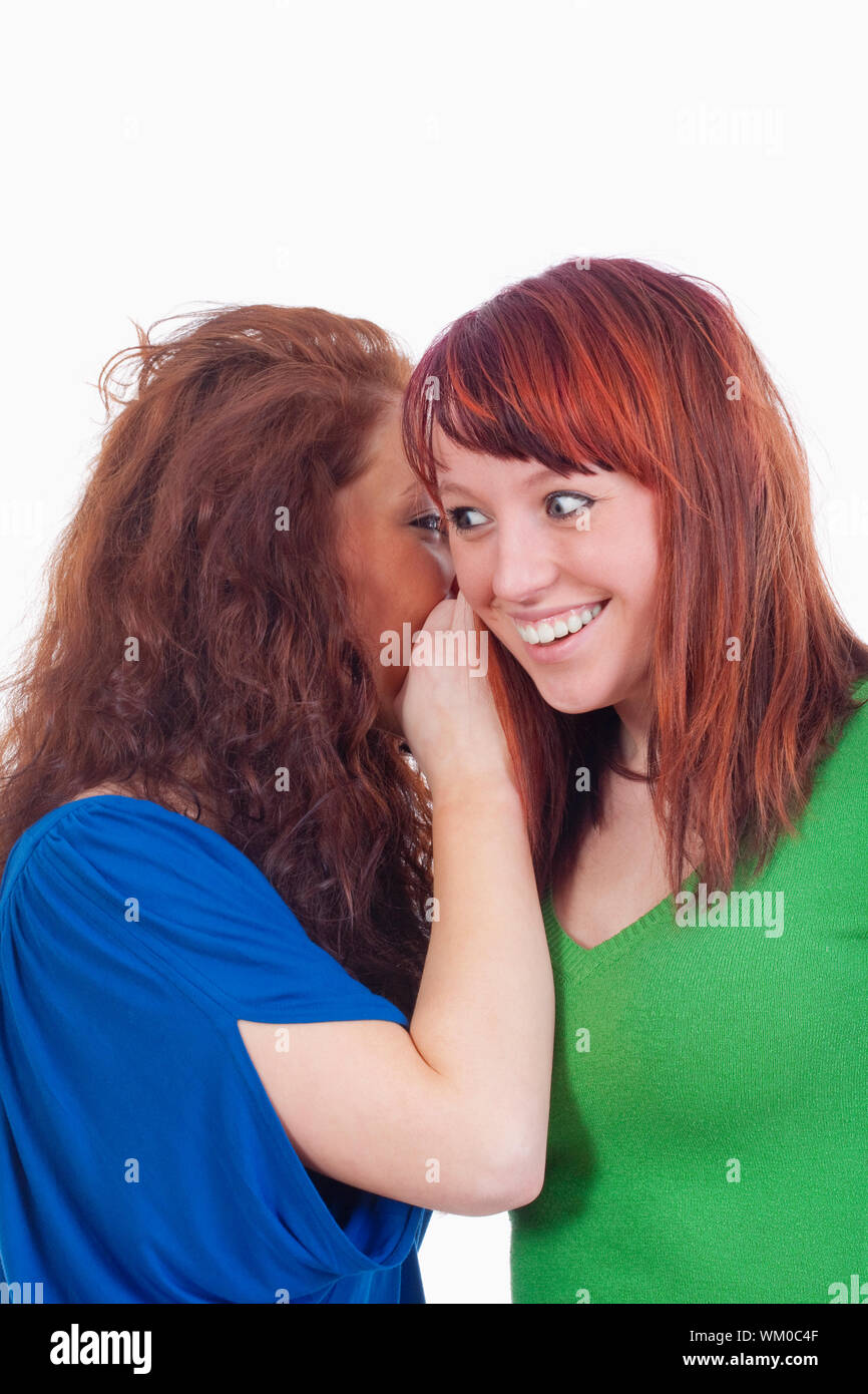 two young women whispering gossip - isolated on white Stock Photo - Alamy