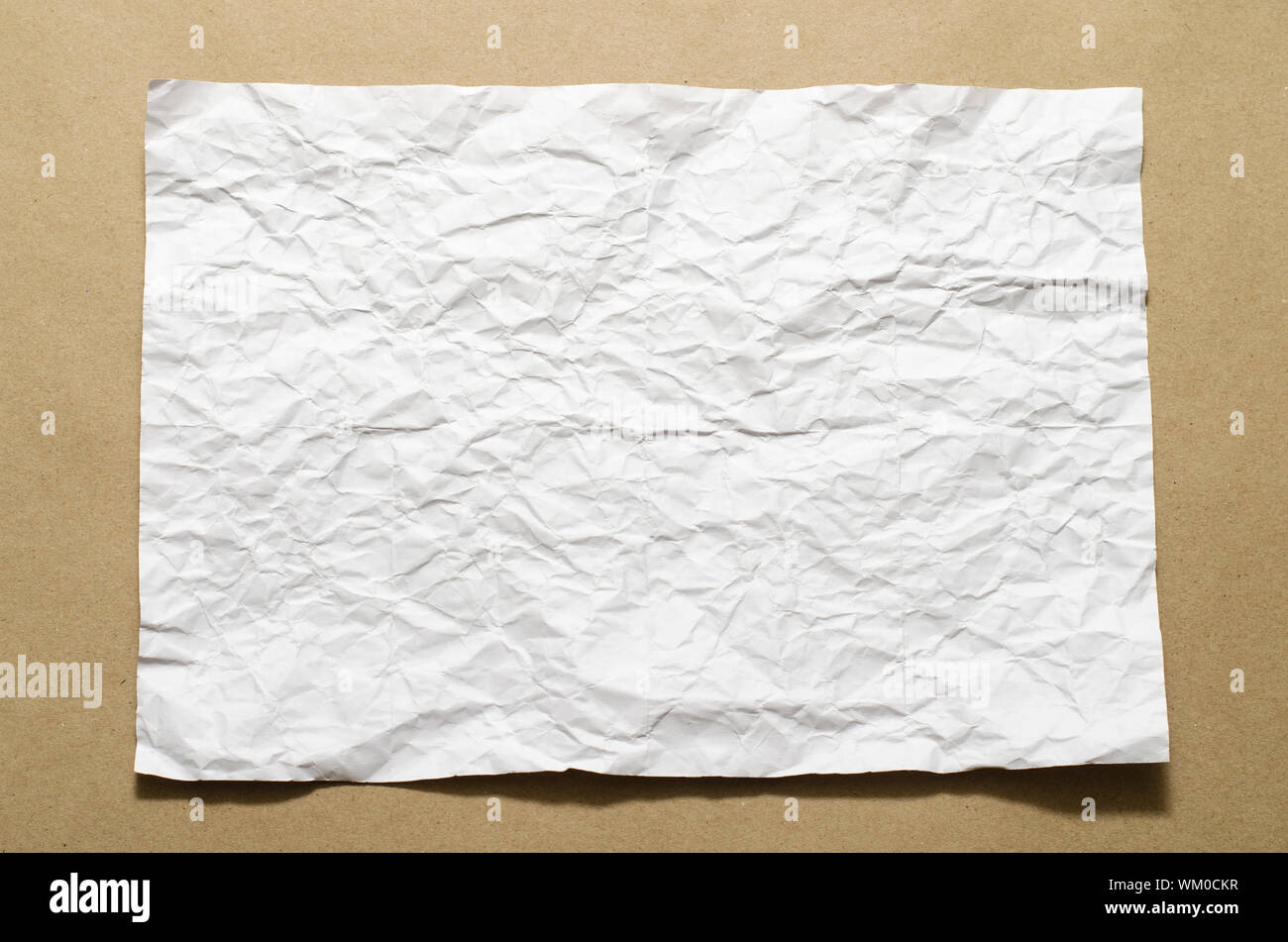 a4 size white crumpled paper on brown color background Stock Photo - Alamy