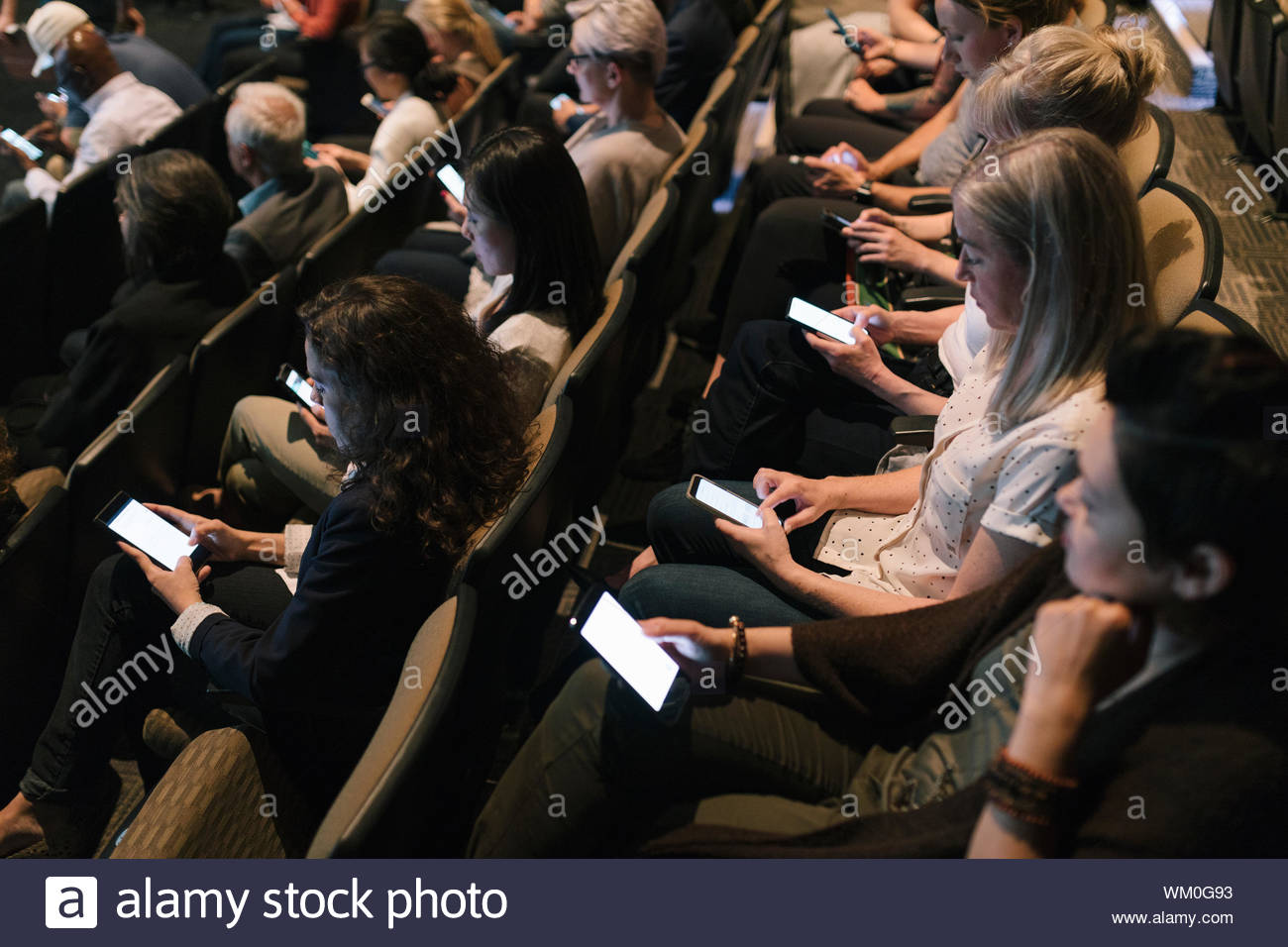 Audience using smart phones during presentation Stock Photo