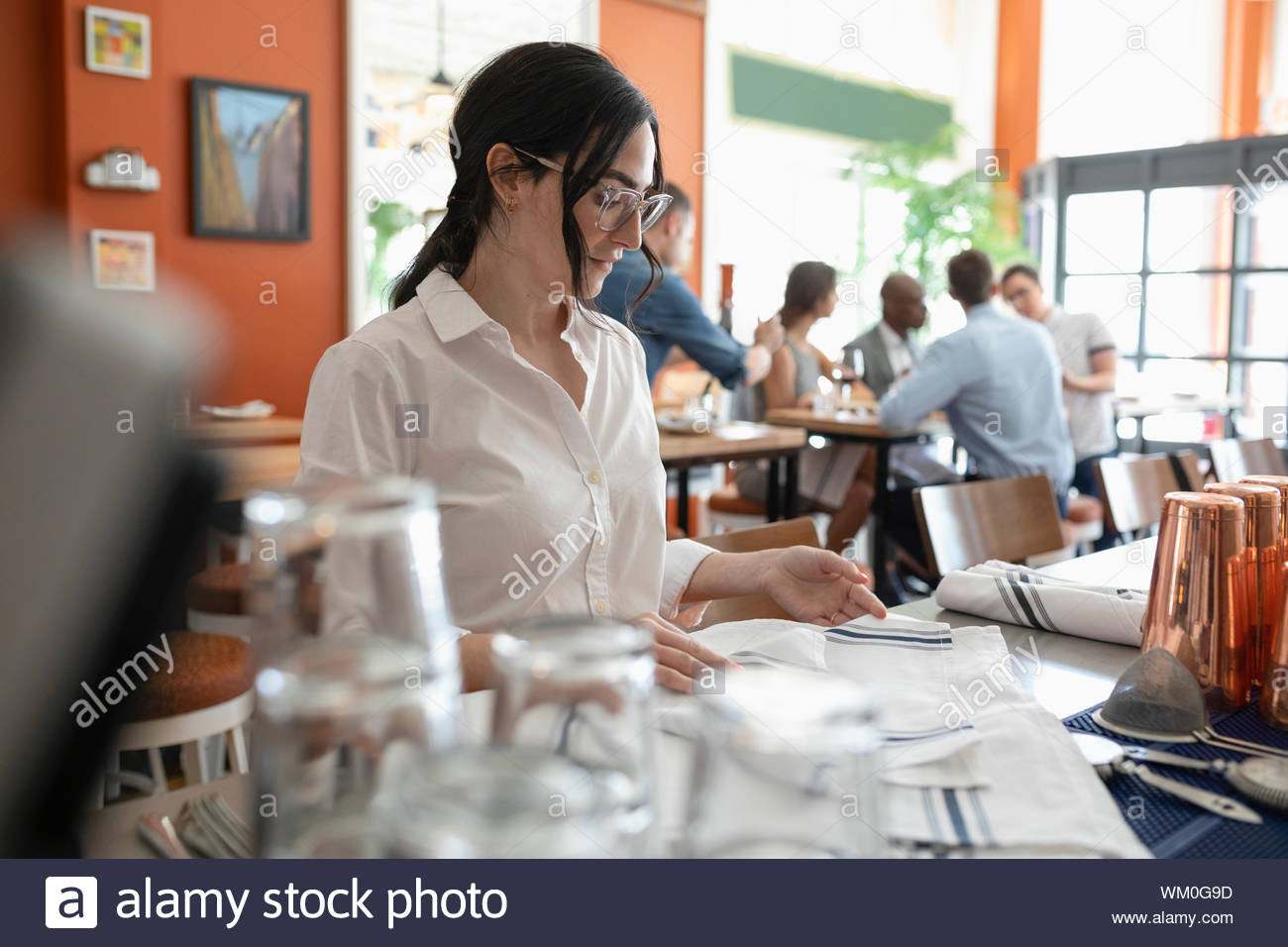 Waitress folding napkins in restaurant Stock Photo Alamy