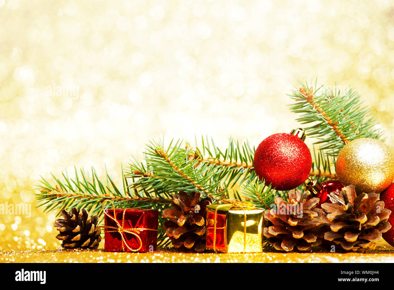 Christmas card with fir tree branch and decoration on golden glitter ...