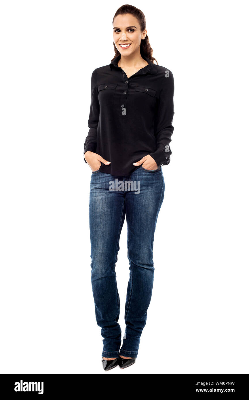 Smiling young woman posing with hands in jeans pockets Stock Photo - Alamy