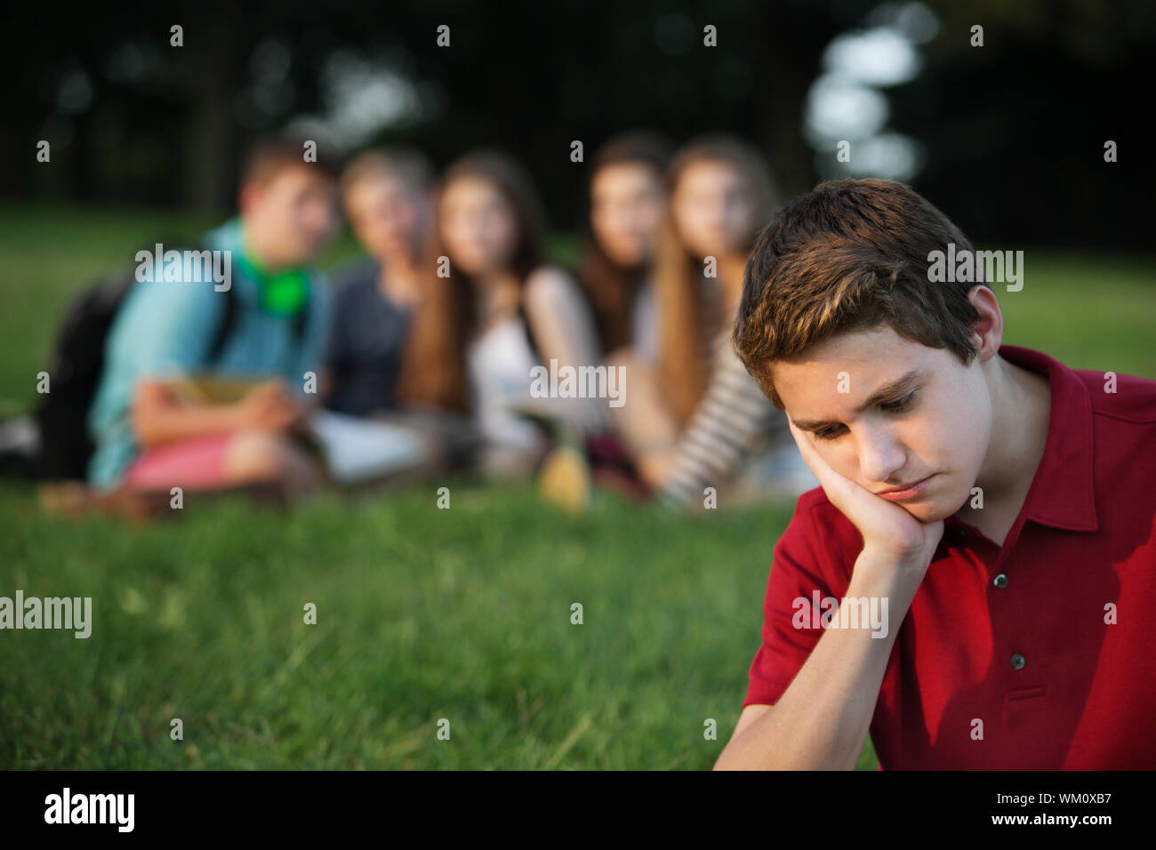 Sulking male caucasian teen with face in hands Stock Photo