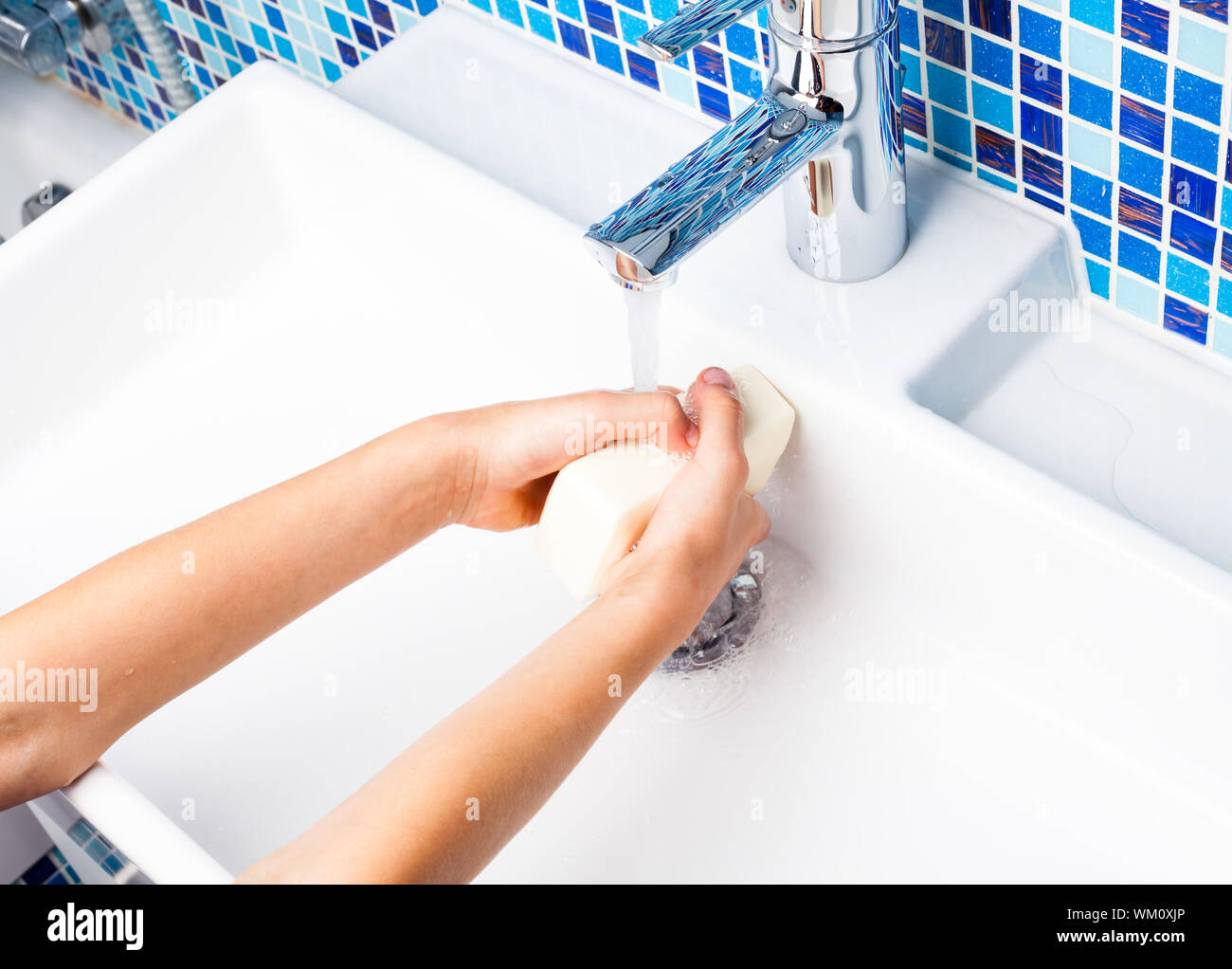 Girl washing her hands with soap in a bathroom sink Stock Photo - Alamy